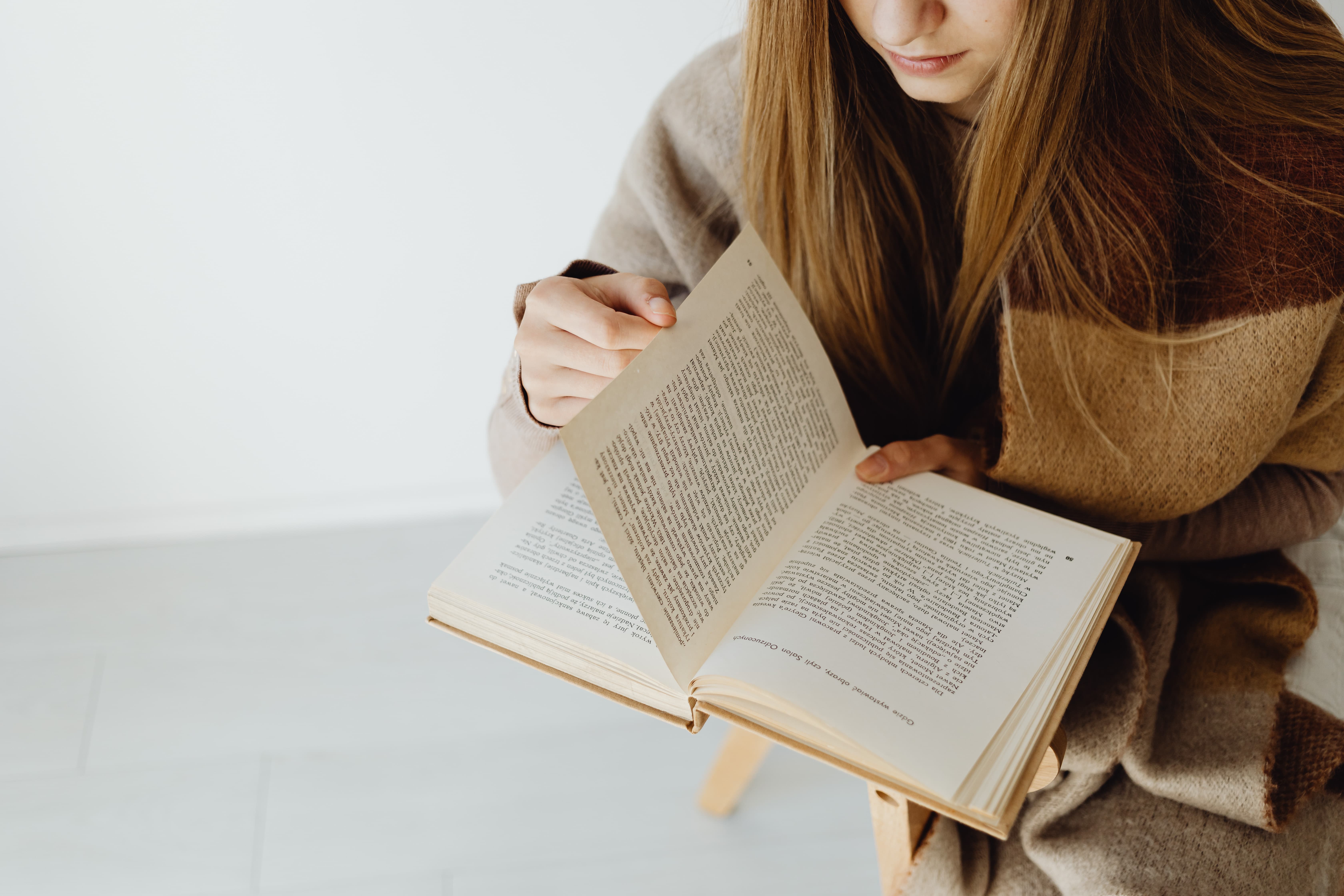 kaboompics_woman-turning-a-page-while-reading-a-book-23038_compressed